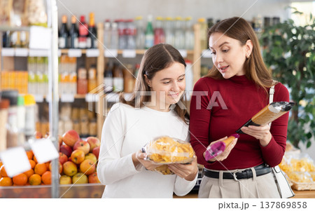 Mother and daughter choose pasta and spaghetti Mother and daughter choose pasta and spaghetti 137869858