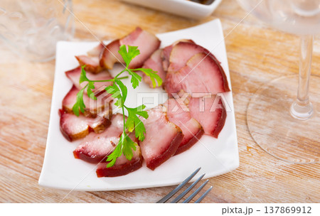 Delicious smoked lard, sliced with greens on white plate Delicious smoked lard, sliced with greens on white plate 137869912