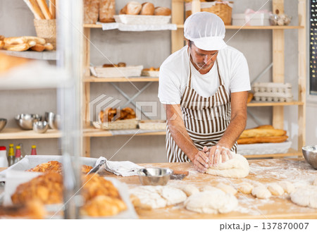 Caucasian guy works in bakery as baker, kneads dough, works with flour. Caucasian guy works in bakery as baker, kneads dough, works with flour. 137870007