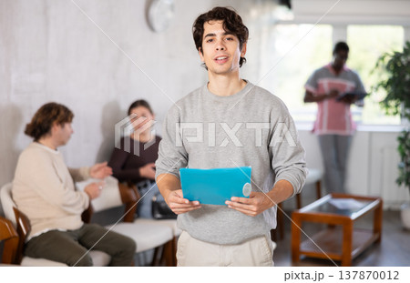 Young guy standing with folder in clinic Young guy standing with folder in clinic 137870012