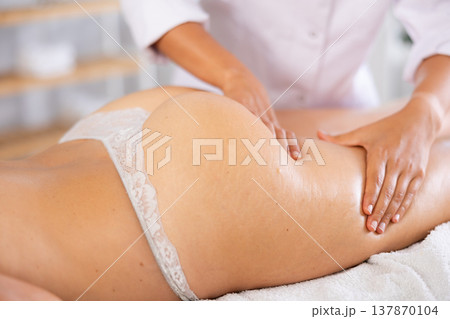 Close-up of young woman getting massage on her thighs and buttocks Close-up of young woman getting massage on her thighs and buttocks 137870104