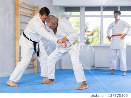 Adult and elderly men training judo fight Adult and elderly men training judo fight 137870106