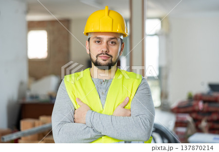 Focused foreman posing on indoor construction site Focused foreman posing on indoor construction site 137870214