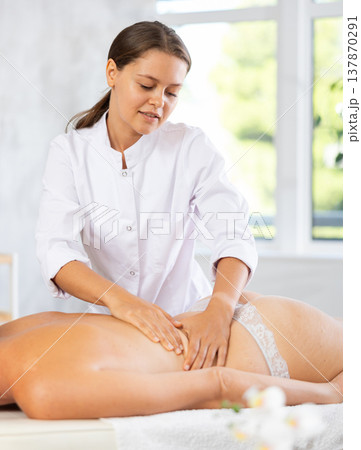 Professional young female massage therapist doing back massage to woman 137870291