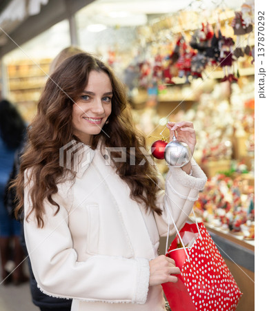 Woman choosing Christmas balls Woman choosing Christmas balls 137870292