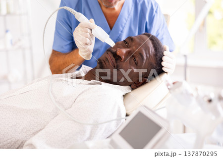 African American experiencing facial skin peeling using ultrasonic scrubber African American experiencing facial skin peeling using ultrasonic scrubber 137870295