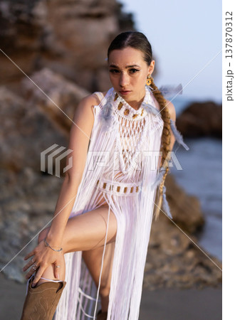 Girl on seashore in sexy and revealing Amazon tribe carnival costume and boots Girl on seashore in sexy and revealing Amazon tribe carnival costume and boots 137870312
