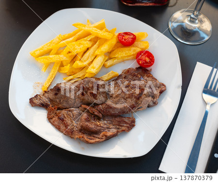 Grilled beef filet steak with side dish of potatoes and tomatoes Grilled beef filet steak with side dish of potatoes and tomatoes 137870379