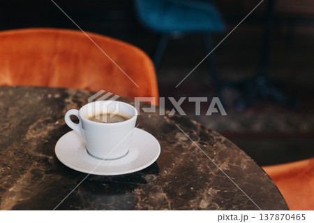 Cup of black coffee on a table in a cafe. Cup of black coffee on a table in a cafe. 137870465