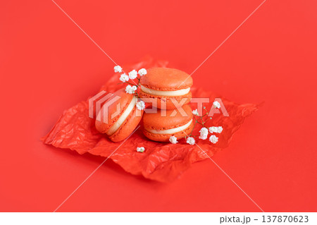 Tasty french macarons on a red background. Tasty french macarons on a red background. 137870623