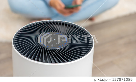 Modern air filter device with sleek design and control panel, enhancing indoor air quality in a cozy living space with copy space Modern air filter device with sleek design and control panel, enhancing indoor air quality in a cozy living space with copy space 137871089