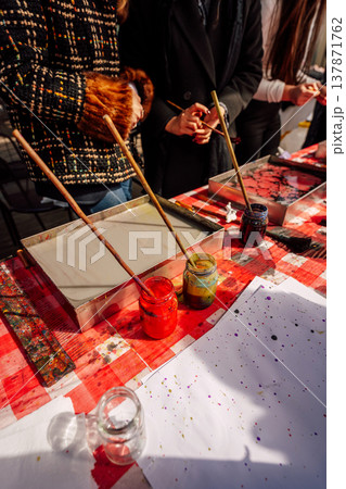 Participants Craft Colorful Designs Outdoors. Art Enthusiasts Create Marbled Patterns In Sunlight Participants Craft Colorful Designs Outdoors. Art Enthusiasts Create Marbled Patterns In Sunlight 137871762