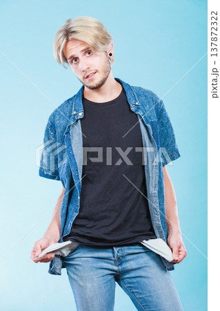 Upset sad man showing empty pockets 137872322
