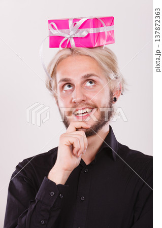Thinking guy with pink gift box on his head Thinking guy with pink gift box on his head 137872363