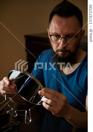 Bearded Man With Glasses Grooming With Handheld Mirror, Concentrated At Home Vanity Table Bearded Man With Glasses Grooming With Handheld Mirror, Concentrated At Home Vanity Table 137872586