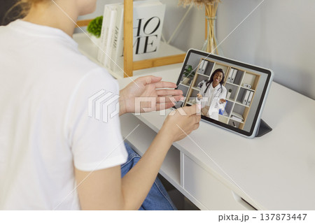 Sick woman listening recommendations having online video call with a doctor at home. Sick woman listening recommendations having online video call with a doctor at home. 137873447