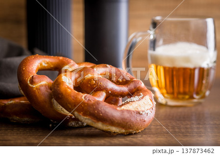 Soft Pretzel With Beer Mug On Wooden Table. Oktoberfest Snack And Rustic Pub Setting Soft Pretzel With Beer Mug On Wooden Table. Oktoberfest Snack And Rustic Pub Setting 137873462