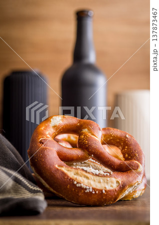 Soft Salted Pretzel on Rustic Wooden Table With Bakery Cloth. Close-Up Food Photography 137873467