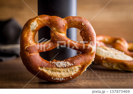 Soft Salted Pretzel on Rustic Wooden Table With Bakery Cloth. Close-Up Food Photography Soft Salted Pretzel on Rustic Wooden Table With Bakery Cloth. Close-Up Food Photography 137873469