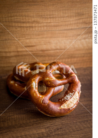 Soft Salted Pretzel on Rustic Wooden Table With Bakery Cloth. Close-Up Food Photography 137873471