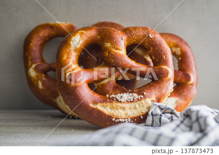 Fresh Soft Pretzels on Striped Cloth . Golden Baked Salted Snack for Breakfast or Picnic 137873473