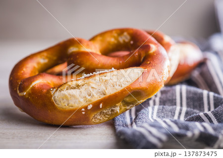 Fresh Soft Pretzels on Striped Cloth . Golden Baked Salted Snack for Breakfast or Picnic 137873475