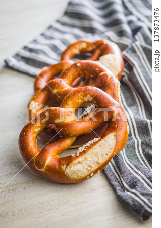 Fresh Soft Pretzels on Striped Cloth . Golden Baked Salted Snack for Breakfast or Picnic Fresh Soft Pretzels on Striped Cloth . Golden Baked Salted Snack for Breakfast or Picnic 137873476