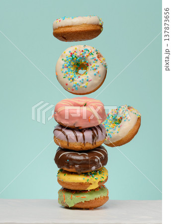 Stack of donuts with various fillings and glazes, several levitating upwards. Stack of donuts with various fillings and glazes, several levitating upwards. 137873656
