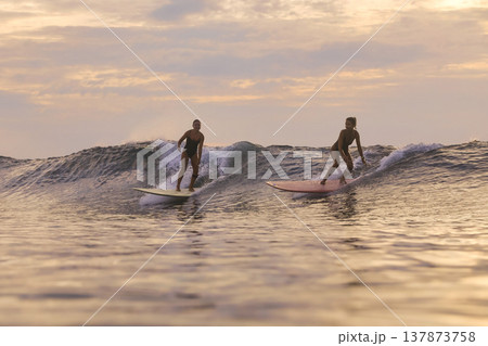 Relaxed Surfers Enjoying Soft Colors And Tranquil Water Ambiance Relaxed Surfers Enjoying Soft Colors And Tranquil Water Ambiance 137873758