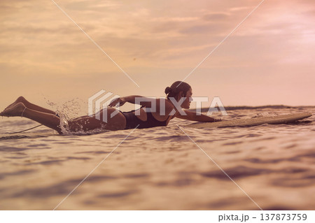Female Comfortably Lying On Board Amidst Evening Waves And Sky Female Comfortably Lying On Board Amidst Evening Waves And Sky 137873759
