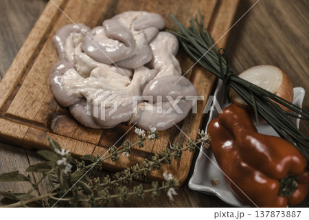 Cow bowels presented on a wooden board with ingredients, ready to grill 137873887