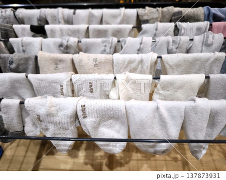 White and colored socks are dried on a metal clothes dryer. White and colored socks are dried on a metal clothes dryer. 137873931