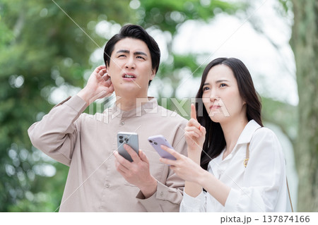 屋外でスマホを見る男女カップル 屋外でスマホを見る男女カップル 137874166