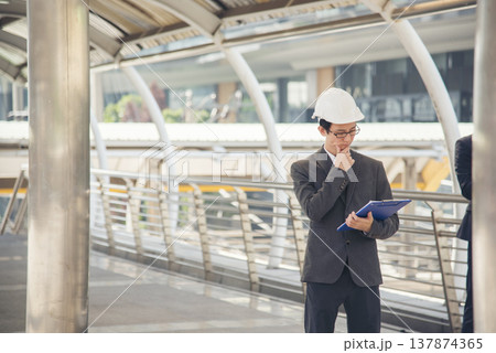 Banner construction engineer man hold blueprint wear blue shirt safety white hard hat at construction site industry plant. Panorama Architecture male civil engineer look at blueprint with copy space. Banner construction engineer man hold blueprint wear blue shirt safety white hard hat at construction site industry plant. Panorama Architecture male civil engineer look at blueprint with copy space. 137874365