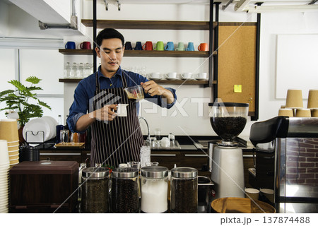 Close up hands coffee barista man make hot cup espresso shot from coffee machine. Cappuccino with milk in italian coffee shop cafe. Close up hands of barista use machine make black drinking hot cup 137874488