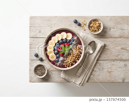 Top-down view of a colorful acai bowl with fruit, granola, and seeds on a rustic wooden surface, smoothie bowl Top-down view of a colorful acai bowl with fruit, granola, and seeds on a rustic wooden surface, smoothie bowl 137874500
