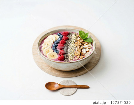 Healthy acai smoothie bowl topped with granola, berries, banana slices, and seeds, food photography Healthy acai smoothie bowl topped with granola, berries, banana slices, and seeds, food photography 137874529