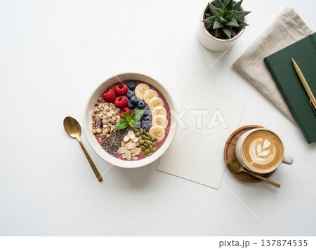 Overhead view of acai bowl topped with berries, banana, and granola, with coffee and notebook, smoothie bowl Overhead view of acai bowl topped with berries, banana, and granola, with coffee and notebook, smoothie bowl 137874535