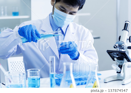 Scientist man holding chemical test glass tube testing science laboratory. Doctor clinic healthcare lab technician diagnosis sample. Asian man scientist working vaccine test medical biochemistry lab 137874547