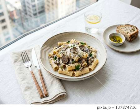 Truffle pasta dish with bread and olive oil by window with italian food Truffle pasta dish with bread and olive oil by window with italian food 137874716