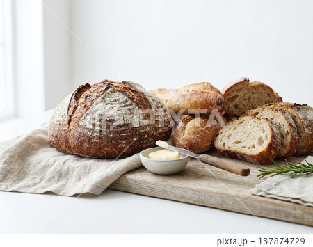 Artisan sourdough bread loaves with butter on a linen cloth and rustic wooden board with baked bread 137874729