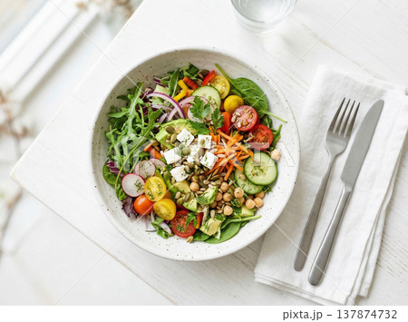 Top view of fresh greek salad with feta cheese, tomatoes, cucumbers, and olives on a white table, vegetable salad Top view of fresh greek salad with feta cheese, tomatoes, cucumbers, and olives on a white table, vegetable salad 137874732
