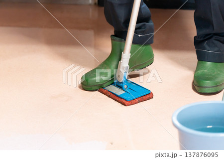 デッキブラシで床磨きする掃除代行業者 137876095