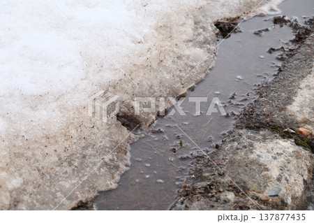 雪解けで泥が露出した冬の道路 雪解けで泥が露出した冬の道路 137877435