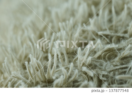 Extreme close-up of white high-pile sherpa fabric showing twisted fibers and soft, wool-like texture 137877548