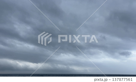 水平線の上を流れる厚い雲の流れ 水平線の上を流れる厚い雲の流れ 137877561