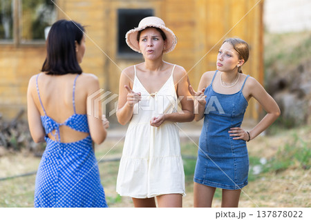 Three women arguing outside country house 137878022