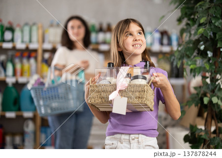 Girl holding a set of care shampoos and shower gels in her hands Girl holding a set of care shampoos and shower gels in her hands 137878244