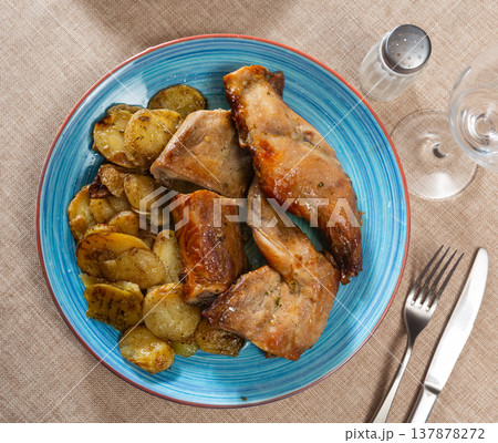 Roasted rabbit pieces with vegetable garnish of fried potatoes Roasted rabbit pieces with vegetable garnish of fried potatoes 137878272