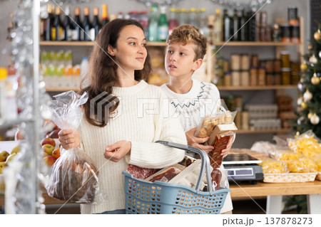 Adult woman with son choosing products in grocery store Adult woman with son choosing products in grocery store 137878273